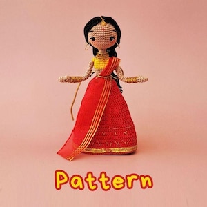 May include: A handcrafted crochet doll wearing a traditional Indian sari. The doll features black hair, gold jewellery, and a red and gold sari. The word "Pattern" is written in orange at the bottom of the image.