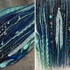May include: A set of blue, teal, and dark blue dreadlocks with decorative accents. The dreadlocks are adorned with white lace, silver charms, beads, and feathers. The overall aesthetic is a blend of bohemian and fantasy styles.