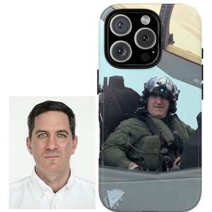May include: A smartphone case featuring a photo of a man in a military aircraft cockpit. The case has a black border and a glossy finish. Next to the case is a studio portrait of a man in a white shirt.