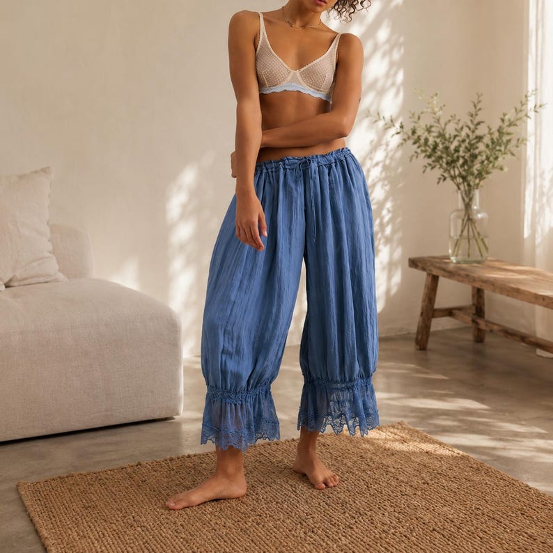 Puede incluir: Pantalones azules de corte holgado con cintura el&aacute;stica fruncida, cord&oacute;n ajustable y acabado de tela texturizada. El dobladillo de cada pernera est&aacute; detallado con un delicado borde de encaje azul a juego que a&ntilde;ade un toque decorativo.