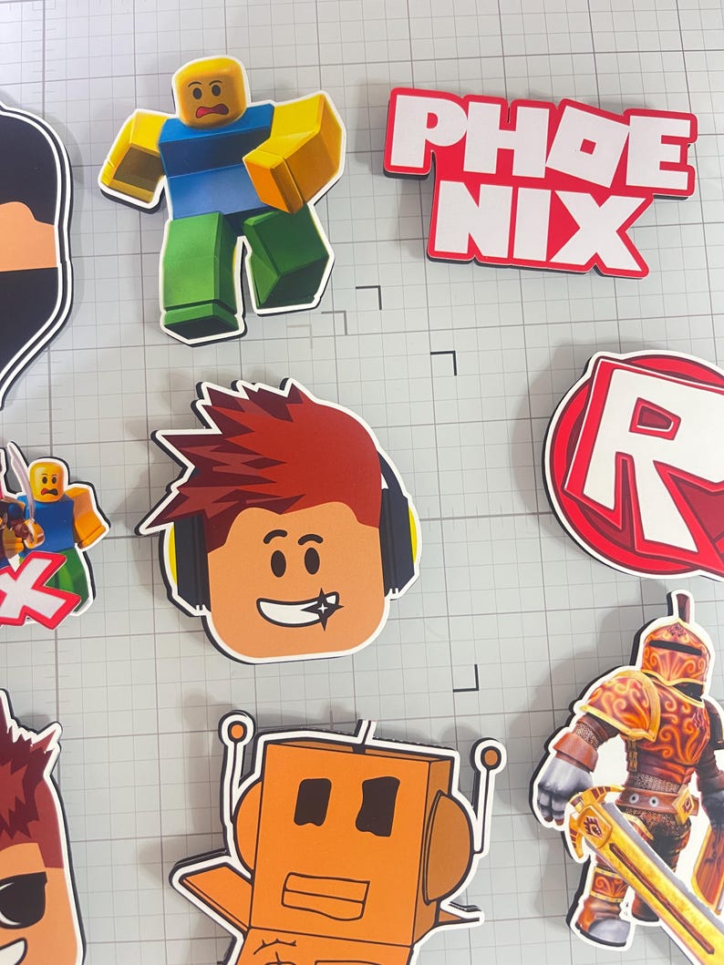 Set of 12 Roblox cupcake toppers featuring popular characters, logos, and icons from the game. Includes layered paper designs with vibrant colors, perfect for gamer-themed birthday parties, cupcakes, and dessert table decor. Ideal for Roblox fans and video game celebrations.