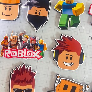 Set of 12 Roblox cupcake toppers featuring popular characters, logos, and icons from the game. Includes layered paper designs with vibrant colors, perfect for gamer-themed birthday parties, cupcakes, and dessert table decor. Ideal for Roblox fans and video game celebrations.