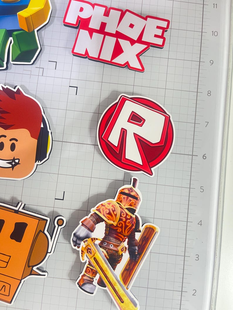 Set of 12 Roblox cupcake toppers featuring popular characters, logos, and icons from the game. Includes layered paper designs with vibrant colors, perfect for gamer-themed birthday parties, cupcakes, and dessert table decor. Ideal for Roblox fans and video game celebrations.