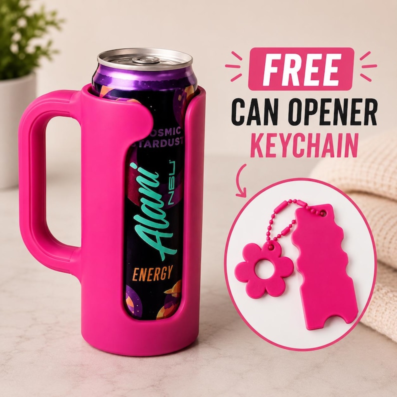 Pu&ograve; includere: Un portabicchieri rosa con manico contiene una lattina di bevanda energetica Alani. &Egrave; incluso un portachiavi apribottiglie rosa gratuito. La lattina ha un design viola e nero.