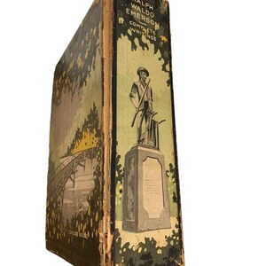 May include: A vintage book titled "Ralph Waldo Emerson Complete Writings." The book's spine features a green and tan cover with an illustration of a statue and a bridge. The cover is worn, suggesting its age.