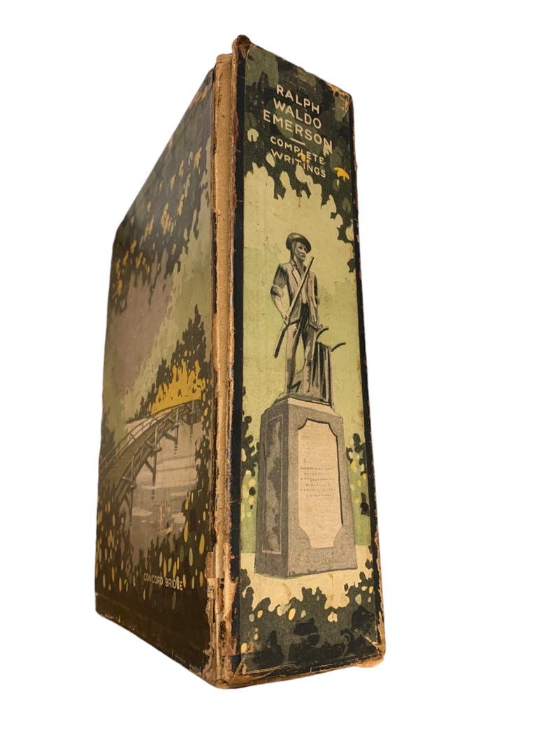 May include: A vintage book titled "Ralph Waldo Emerson Complete Writings." The book's spine features a green and tan cover with an illustration of a statue and a bridge. The cover is worn, suggesting its age.