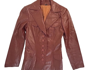 May include: A brown leather jacket with a button-up front and two flap pockets. The jacket has a notched collar and long sleeves.