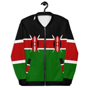 May include: A black, red, and green bomber jacket featuring the Kenyan flag design. The jacket has a zipper closure and a black collar. The design includes the Kenyan flag's colors and shield emblems. The jacket is hanging on a black hanger.