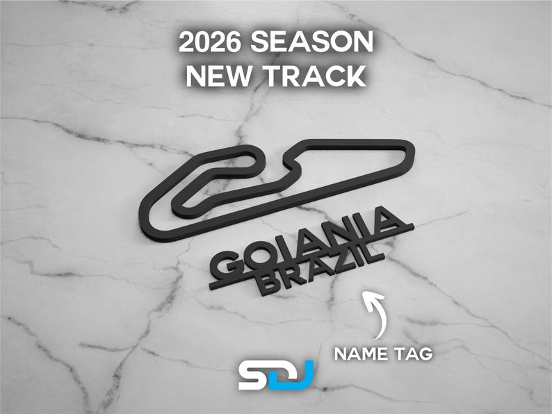 以下が含まれることがあります： 「2026 SEASON NEW TRACK」と「GOIANIA BRAZIL」の文字が入った黒いレーストラックの輪郭。白い矢印が「NAME TAG」を指しています。「SDJ」のロゴが左下にあります。背景は大理石模様です。
