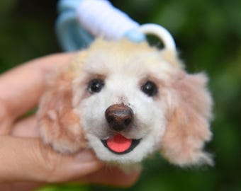 May include: A soft toy dog with a light brown and white coat, a pink tongue, and black eyes. The dog has a blue and white accessory and the text "PETYCHERY" is visible.