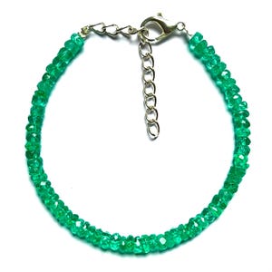 Puede incluir: Una delicada pulsera con pequeñas cuentas de esmeralda facetadas. Las vibrantes piedras preciosas verdes están conectadas por una cadena y un cierre de color plateado, creando una joya sencilla pero elegante.