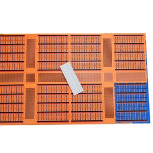 May include: A set of orange and blue circuit boards with a white breadboard in the center. The circuit boards have a grid pattern with black lines.