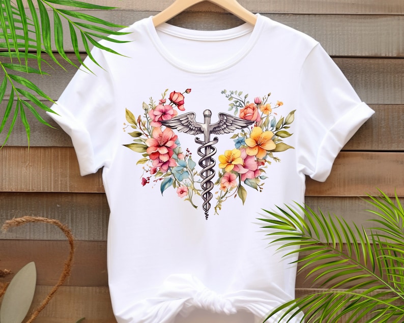May include: White t-shirt with a floral design featuring a medical caduceus symbol in the center.