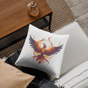May include: White throw pillow with a colorful illustration of a phoenix rising from flames.