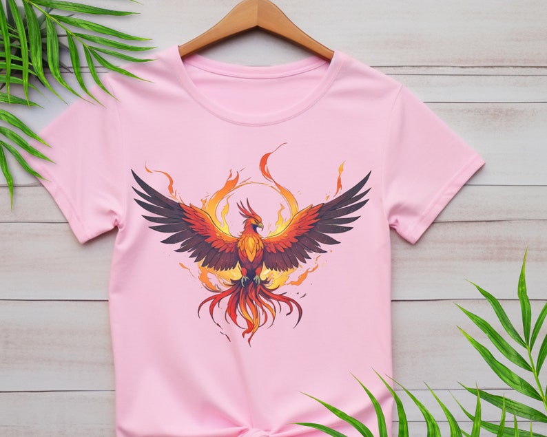 May include: Pink t-shirt with a graphic of a phoenix rising from flames.