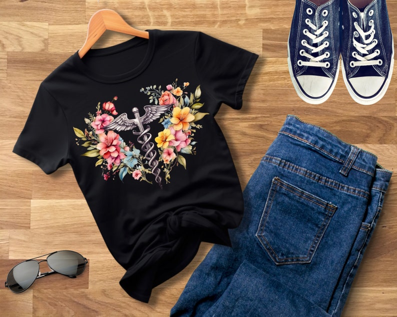 May include: Black t-shirt with a floral design featuring a medical caduceus symbol. The flowers are pink, yellow, and blue.