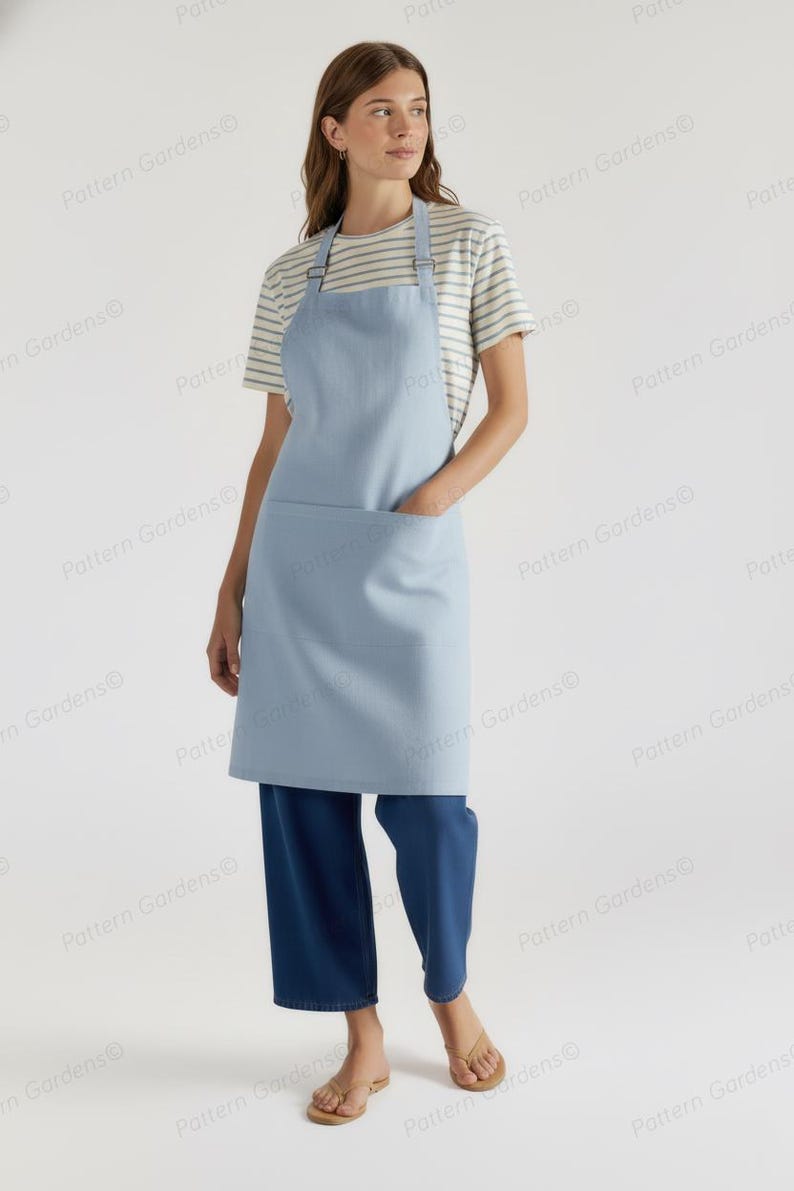 Puede incluir: Un delantal azul claro con un bolsillo delantero grande y correas ajustables. El delantal se usa sobre una camiseta a rayas y pantalones azul oscuro. La persona lleva sandalias doradas.