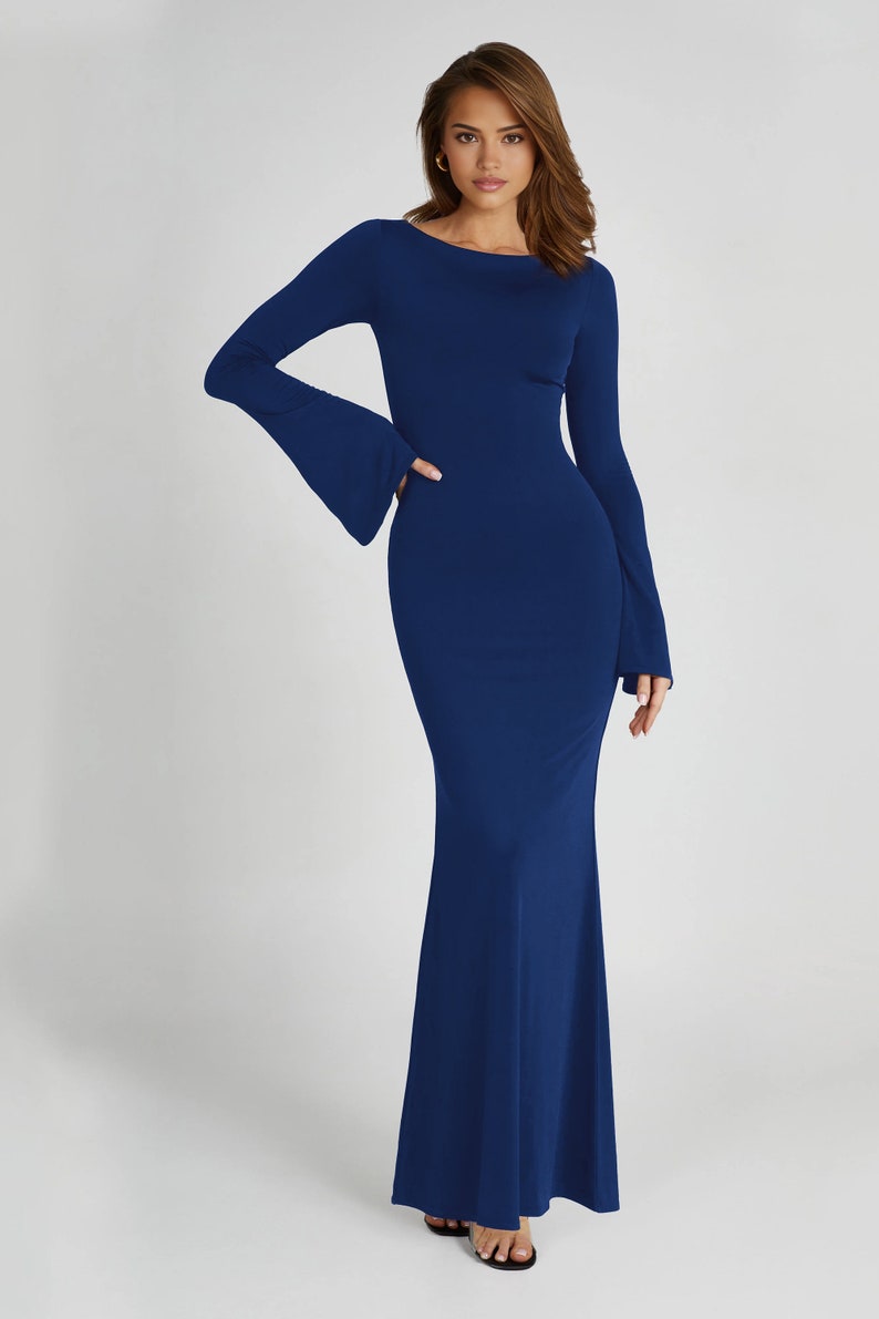May include: A long-sleeved, dark blue maxi dress with a fitted bodice and a flowing skirt. The dress has a scoop neckline and bell sleeves.