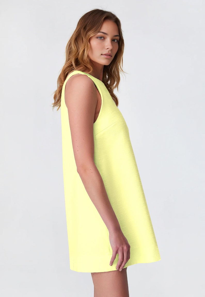 May include: A sleeveless, bright yellow mini dress with a scoop neck.