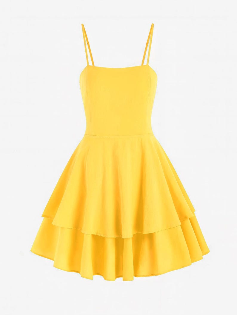 May include: A bright yellow dress with thin spaghetti straps and a tiered skirt. The dress has a fitted bodice and a flared, layered skirt. The fabric appears to be smooth and lightweight, suitable for warm weather.