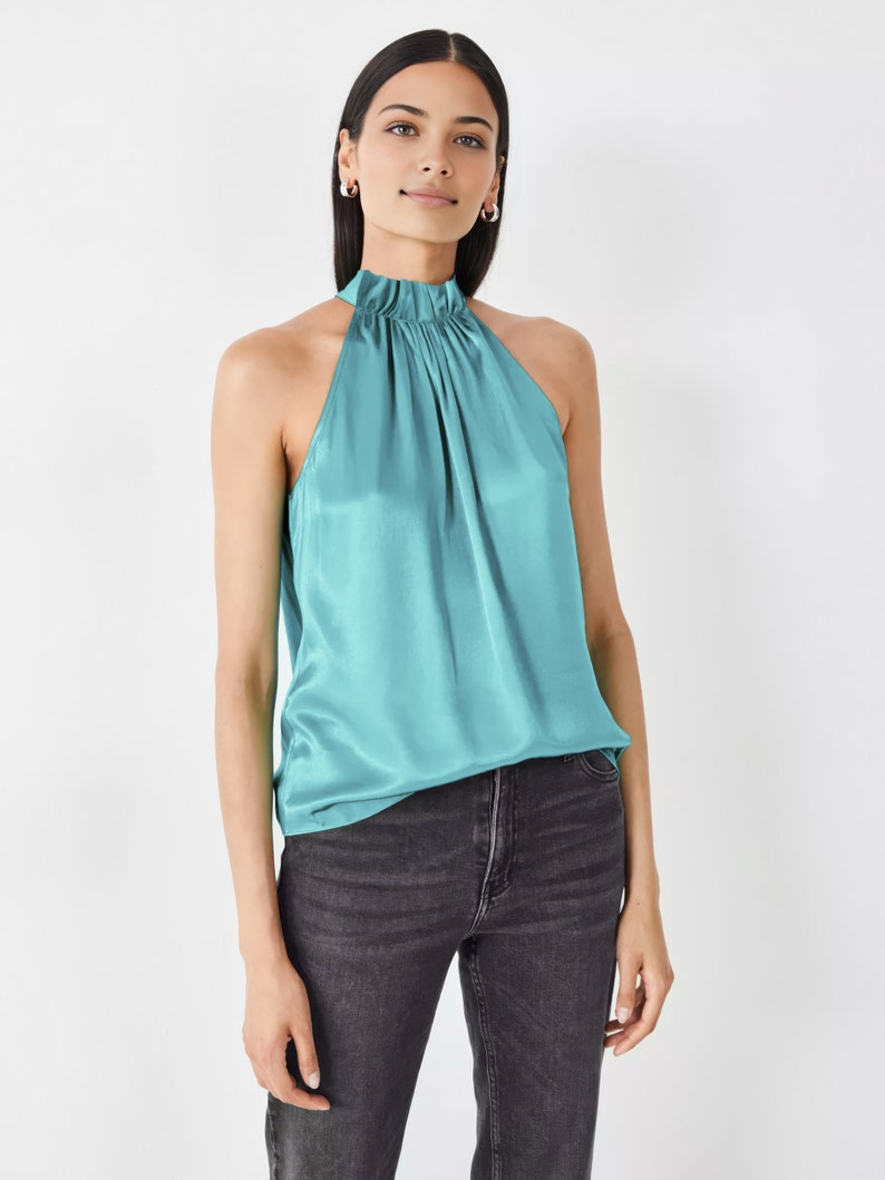 Op de afbeelding: Een turquoise haltertop van satijn met een geplooide halslijn.