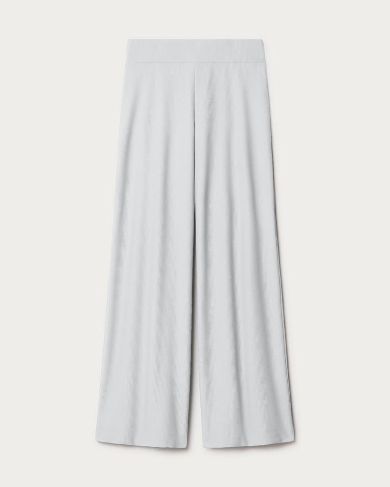 May include: Light gray wide-leg pants with a smooth, slightly textured fabric.