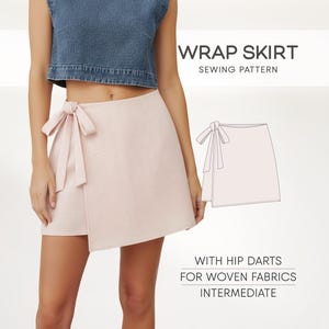 May include: A light pink wrap skirt with a bow detail. The skirt is paired with a denim crop top. Text on the image reads "WRAP SKIRT SEWING PATTERN" and "WITH HIP DARTS FOR WOVEN FABRICS INTERMEDIATE".