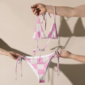 May include: Pink and white checkered bikini top and bottom with adjustable straps. The bikini top is a triangle style and the bottom is a cheeky style.