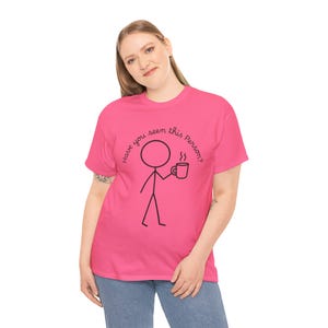 May include: A vibrant pink t-shirt with the phrase "Have you seen this Person?" and a stick figure holding a coffee cup printed in black. The stick figure has a circle for a head and simple lines for the body and legs.