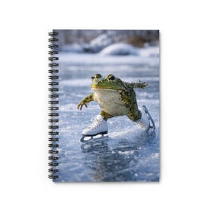 Peut inclure: Cahier à spirales avec une image amusante d'une grenouille verte patinant sur un lac gelé. La grenouille porte des patins à glace blancs, sur fond de paysage hivernal flou. La couverture du cahier est un design amusant et original.