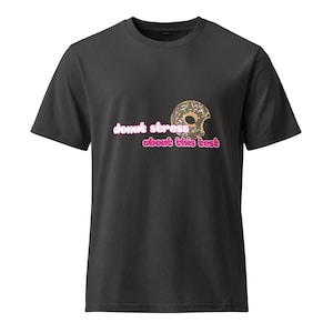 May include: Dark gray t-shirt featuring a colorful donut graphic with sprinkles and the text "donut stress about this test" in pink and white. The shirt is a casual, everyday wear item.