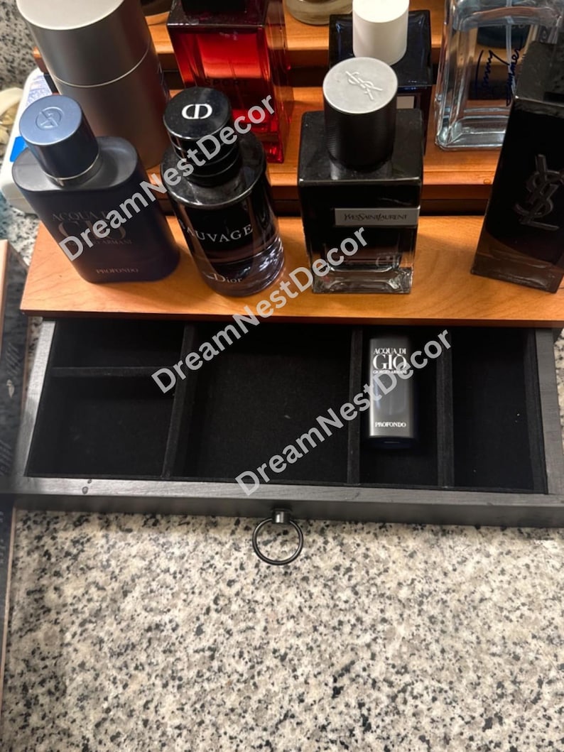 May include: A wooden box with a black velvet lined drawer. The drawer has multiple compartments for storing small items. The box is open and the drawer is pulled out. The drawer has a silver ring pull.