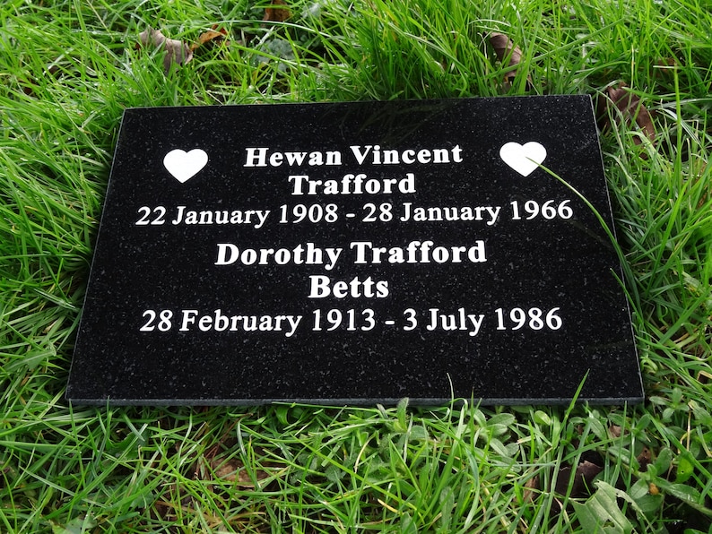 May include: Black granite headstone with white lettering. The inscription reads "Hewan Vincent Trafford 22 January 1908 - 28 January 1966 Dorothy Trafford Betts 28 February 1913 - 3 July 1986". Two white hearts are on either side of the inscription.