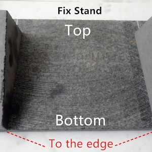 May include: A gray stone fix stand with two upright pieces on either side. The stand is labeled "Fix Stand", "Top", and "Bottom". A red dashed line points to the bottom edge of the stand and says "To the edge".