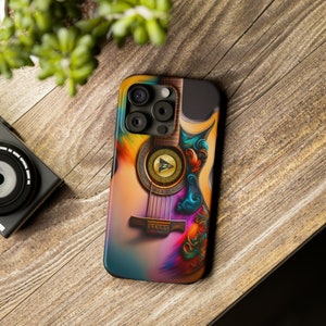 May include: A colourful phone case featuring a guitar design. The guitar is painted in shades of blue, green, yellow, and orange. The case has a black border and a camera lens cutout.