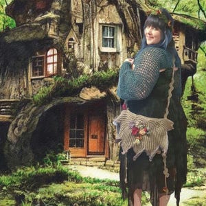 May include: A woman wearing a teal crochet top and a long black skirt with a crocheted trim stands in front of a whimsical treehouse. She is carrying a crocheted bag with floral embellishments.
