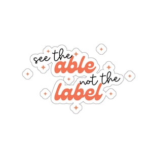 May include: A pink and white sticker with the text "See the able not the label" in black lettering. The sticker is surrounded by small pink stars.