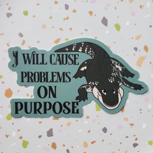 May include: A teal blue sticker with a black alligator and the text "I will cause problems on purpose".