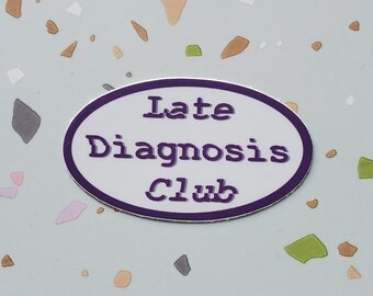 May include: A purple oval sticker with white text that reads "Late Diagnosis Club". The sticker is on a light blue background with brown, white, and green flecks.
