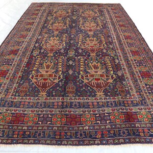 May include: A traditional Persian rug with a deep blue background and intricate floral patterns in shades of red, yellow, and cream. The rug has a fringed border and is woven with a high knot count.