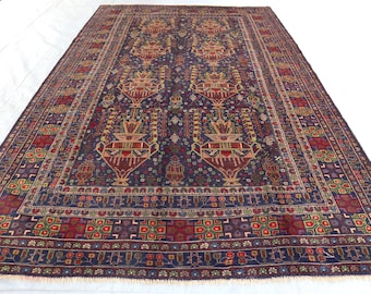 May include: A traditional Persian rug with a deep blue background and intricate floral patterns in shades of red, yellow, and cream. The rug has a fringed border and is woven with a high knot count.