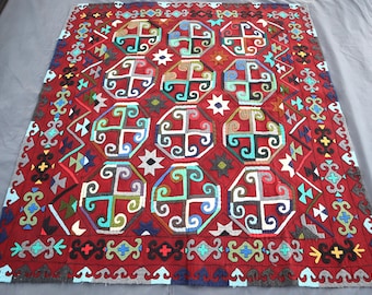 Può includere: Un tappeto rosso con un complesso motivo geometrico multicolore. Il design include forme ottagonali ripetute con motivi a croce, stelle e altri elementi decorativi. Il bordo presenta un design dettagliato e colorato.