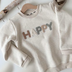 Handgemachter Kinderpullover in Creme/helles beige meliert mit Chenille Patch HAPPY