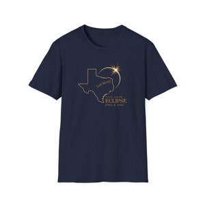 May include: Navy blue t-shirt featuring a gold outline of the state of Texas with "Fort Worth" and a solar eclipse design. The text "TOTAL SOLAR ECLIPSE APRIL 8, 2024" is also printed on the shirt.
