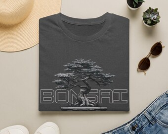 Könnte beinhalten: Ein dunkelgraues T-Shirt mit einer detaillierten Grafik eines Bonsai-Baums, zentriert über dem Wort BONSAI in einer fetten, umrandeten Schrift. Das Design ist in Grau- und Weißtönen gedruckt und zeigt die komplexen Äste und den Stamm des Baumes.