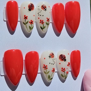 Stunning Red Nails with Adorable Ladybug and Flower Design