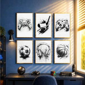 Op de afbeelding: Zes ingelijste kunstprints met gouden frames, elk met een zwart-witte schets van sportuitrusting en gamecontrollers. De prints bevatten een voetbal, basketbal, hockeystick en puck, koptelefoon en twee gamecontrollers.
