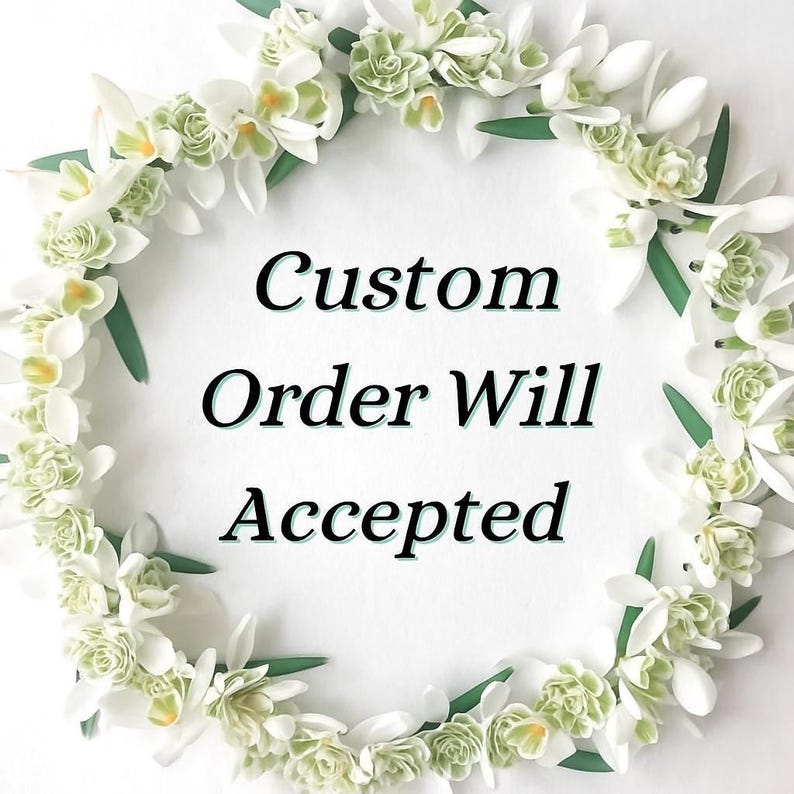 May include: A circular floral arrangement of white and green flowers and leaves. The flowers are arranged in a wreath shape, with the text "Custom Order Will Accepted" in the center.