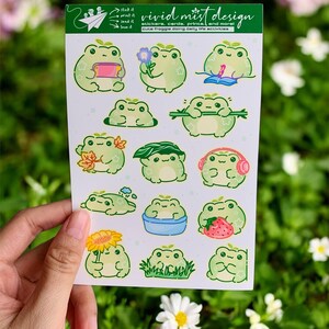 At the top of the sheet is a green header card branded with playful line art and text, introducing the sticker collection. Below it, multiple individual frog stickers are arranged neatly across a light lavender background with faint polka dots. Each frog has a slightly different pose and activity, making the sheet feel lively and story-driven.