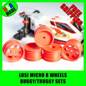 May include: Set of four orange micro buggy wheels for a Losi micro B car. The wheels have different designs, including a spoke design and a hole design.